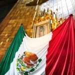 Bandeira mexicana sobre La Virgen de Guadalupe dentro da Basílica de Guadalupe na Cidade do México.